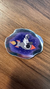 a sticker with an astronaut on a rocket